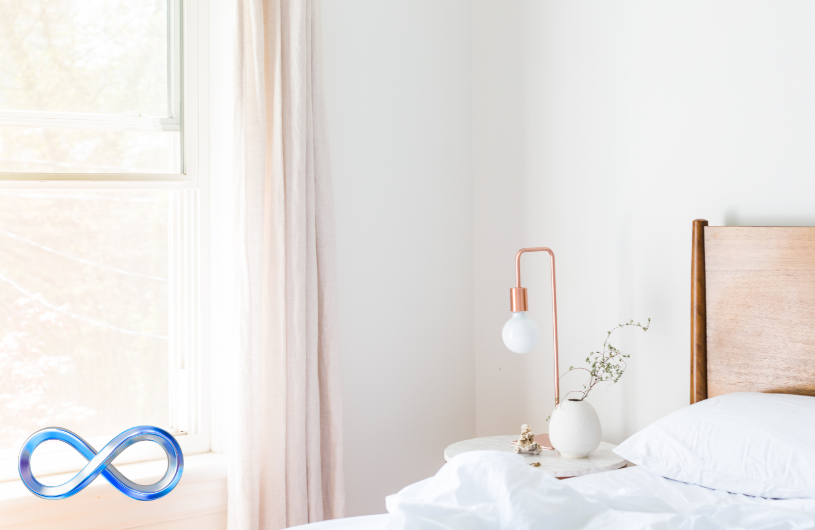 Bedroom with a wooden headboard and white bedding, featuring a blue infinity symbol.